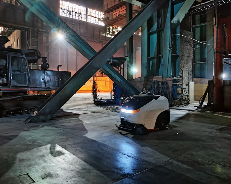 Industrial yard with an autonomous sweeper servicing laydown area and plant road